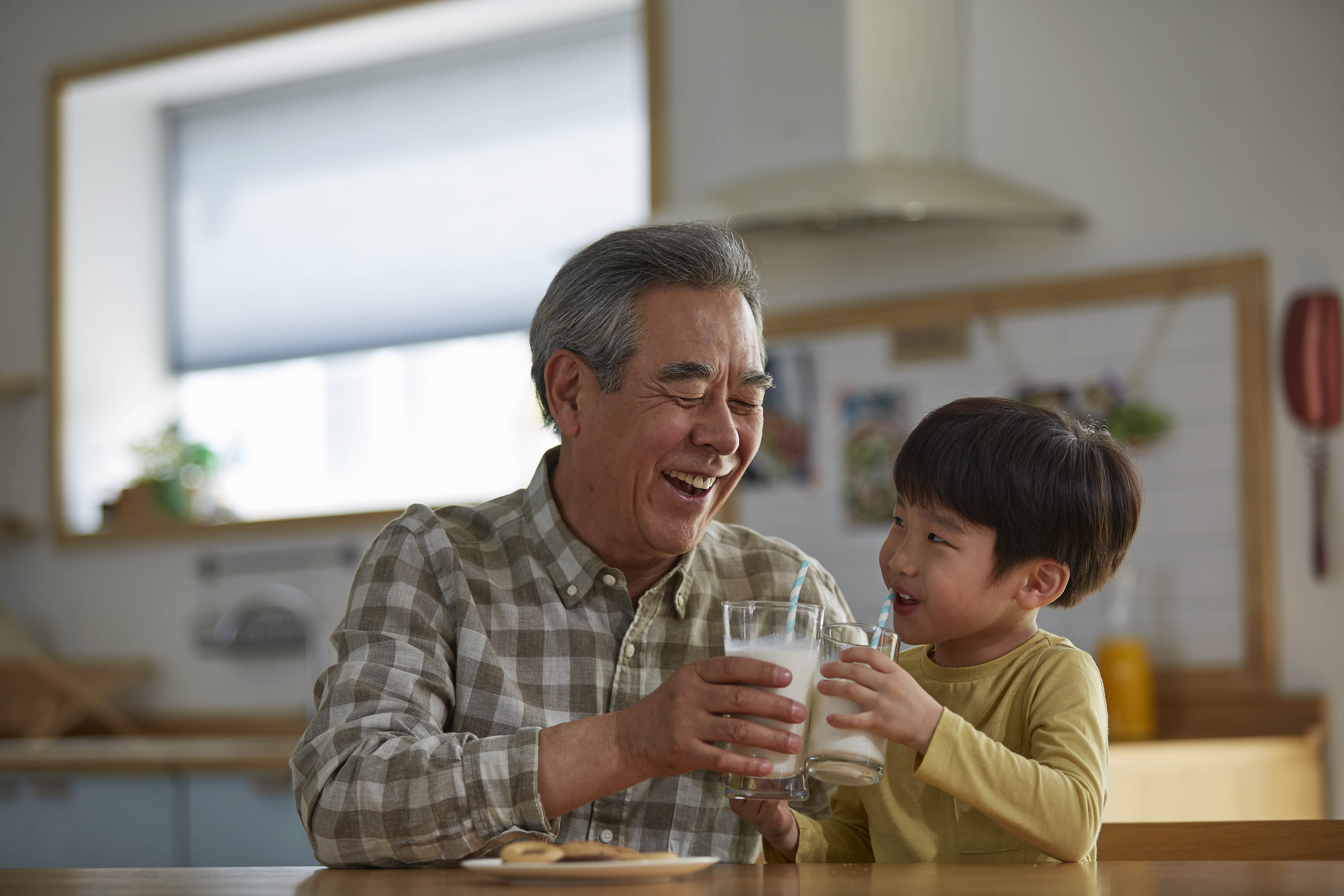 grandfather having milk and cookies with grandson